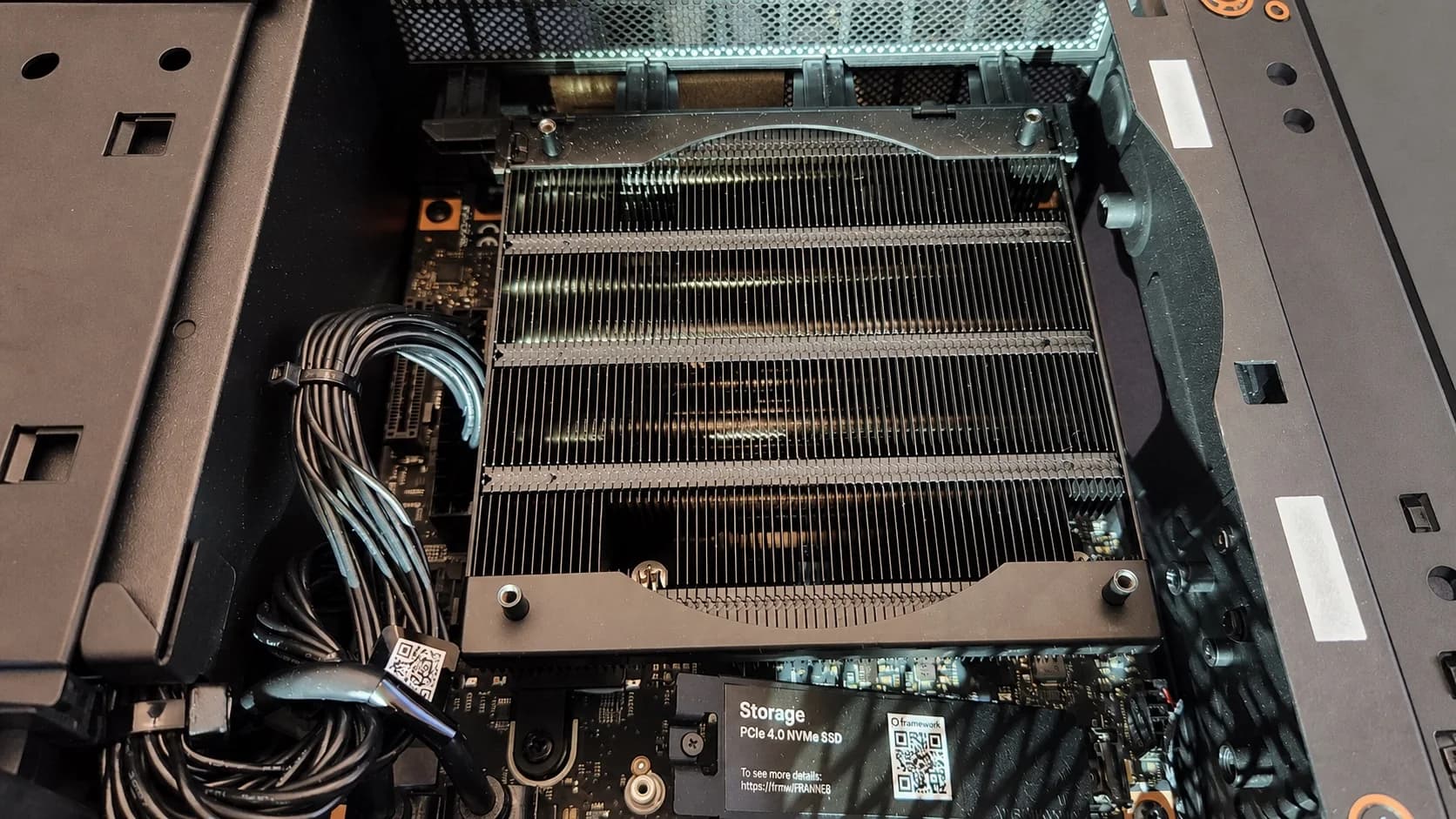 The open AMD Strix Halo system showing its heatsink, cabling, motherboard, and NVMe storage.